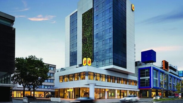 A modern hotel with a prominent vertical garden, large windows, and a blue and white facade. - Premier Inn Koblenz City (Koblenz)