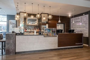 Eine Bar mit Theke, hängenden Lampen und einer Wand mit motivierenden Sprüchen.