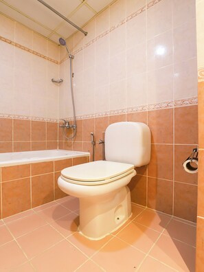 Ein Badezimmer mit Toilette, Dusche und Badewanne.