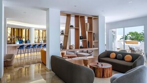 A modern hotel lobby with a bar area, seating, and a view of the outdoors. - TUI Blue Palm Beach Hammamet (Hammamet)