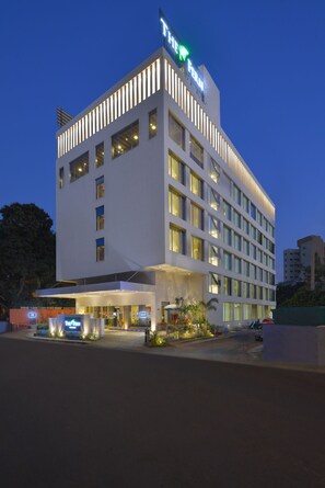 A modern hotel building with a prominent sign, multiple floors, and a well-lit entrance. - THE Fern AN Ecotel Hotel Vadodara (Vadodara)