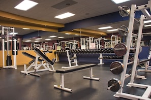 A gym with weightlifting equipment, benches, and dumbbells. - Radisson Red Deer Hotel (Red Deer)