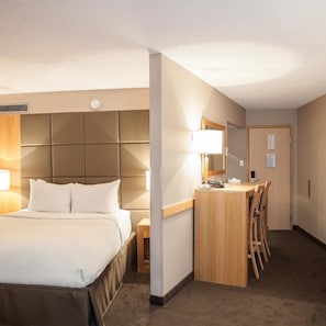A hotel room with a bed, a desk, and a chair. - Ihotel & Conference Centre Red Deer (Red Deer)