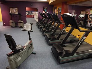 Ein Fitnessraum mit Laufbändern und Crosstrainern.