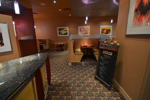 A restaurant with booths, a counter, and a menu board listing specials. - Radisson Red Deer Hotel (Red Deer)