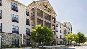 Ett hotell med flera våningar, med en skylt som visar texten ”MarinStay Suites”. Hotellet har en fasad av sten, flera balkonger och en parkeringsplats med reserverade platser för rörelsehindrade.