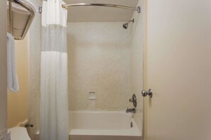 Een badkamer met een douche, een handdoekhouder en een toilet.