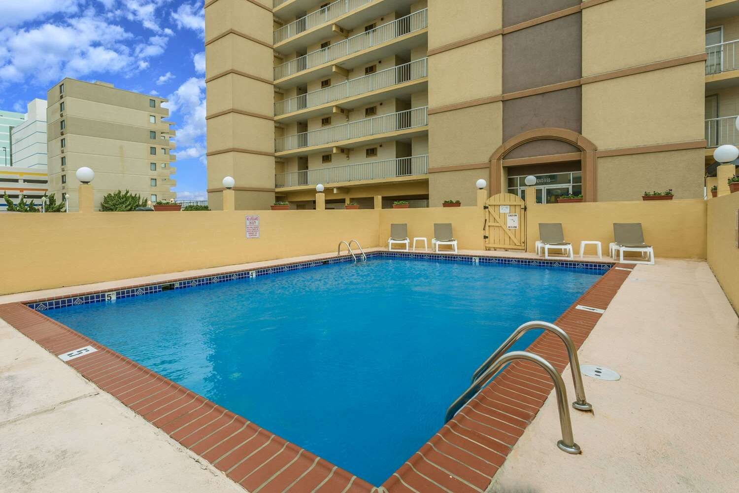 Ein rechteckiger Swimmingpool mit einer gefliesten Kante, umgeben von einem Mauerwerk-Rand.