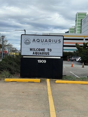 En skylt för hotellet Aquarius, med en logotyp som föreställer en sol och en våg, som välkomnar besökarna.