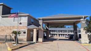 A building with a gas station, a flag, and a parking lot. - Houston/willowbrook/hwy 249 (Houston)