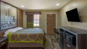 A hotel room with a bed, a desk, a TV, and a window with curtains. - Super 8 By Wyndham Tulsa/arpt/st Fairgrounds (Tulsa)