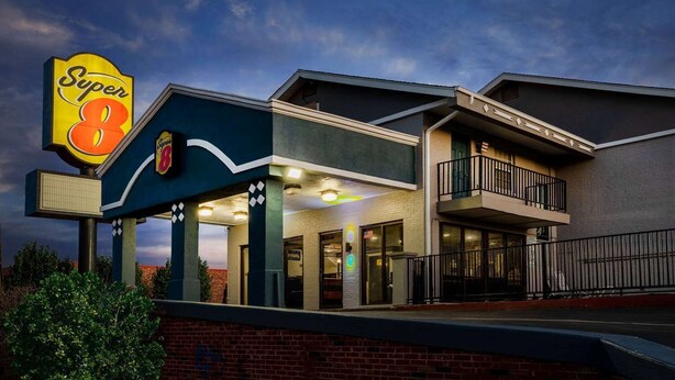 A Super 8 hotel with a covered entrance, a balcony, and a brick facade. - Super 8 By Wyndham Tulsa/arpt/st Fairgrounds (Tulsa)