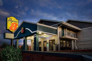Un hotel Super 8 con entrada cubierta, balcón y fachada de ladrillo.