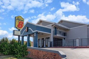 A Super 8 motel with a two-story building, a covered entrance, and a fenced parking area. - Super 8 By Wyndham Tulsa/arpt/st Fairgrounds (Tulsa)