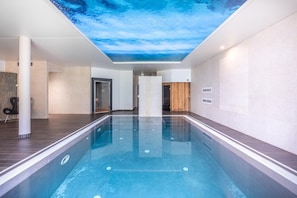 A swimming pool with a ceiling mural, a wooden floor, and a modern interior design. - Charme Hotel Montbeliard Sud (Arbouans)