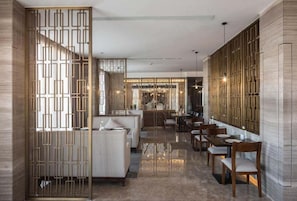 A modern interior with a dining area, seating, and a kitchen in the background.
