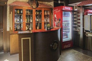 Baarialue, jossa on Coca-Cola-jääkaappi, juomakaappi ja baaritiski.