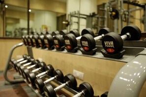 Eine Reihe von VIVA Power Kurzhanteln an einem Gestell in einem Fitnessstudio.