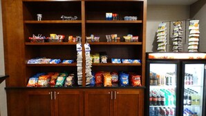 A snack and beverage refrigerator stocked with various items, including chips, snacks, and drinks. - Best Western Premier Airport/expo Center Hotel (Louisville)