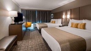 A hotel room with two beds, a desk with a lamp, a chair, and a television. - Best Western Premier Airport/expo Center Hotel (Louisville)