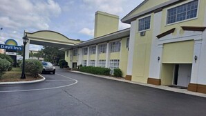 A Days Inn with a curved driveway, a gas station sign, and a building with multiple windows and a flat roof.