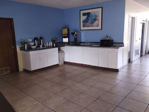 A kitchen with white cabinets, a coffee maker, and a microwave. - Days Inn by Wyndham Gainesville University (Gainesville)