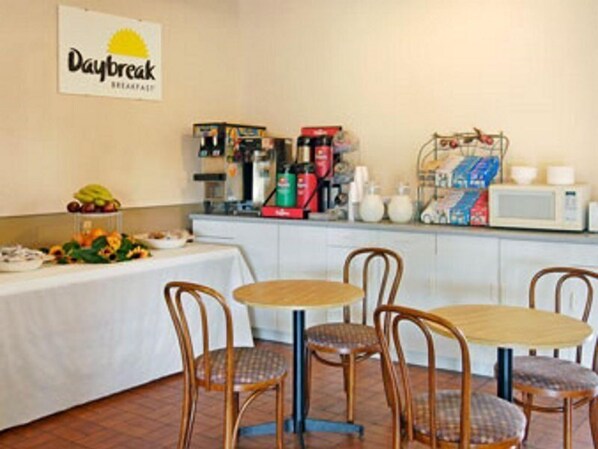 A breakfast area with a table, chairs, a microwave, and a coffee station. - Days Inn by Wyndham Gainesville University (Gainesville)