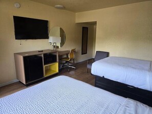 A hotel room with a bed, a desk with a chair, a television, and a mirror. - Days Inn by Wyndham Gainesville University (Gainesville)