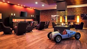 A lounge area with seating, a fireplace, and a television. - Lindner Hotel Nurburgring Congress (Nuerburg)