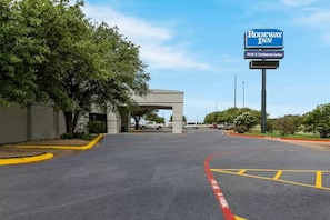Un parking avec un panneau indiquant l’hôtel Rodeway Inn et son centre de conférences.