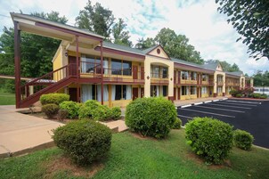 A motel with a two-story structure, a covered outdoor area, and a parking lot.