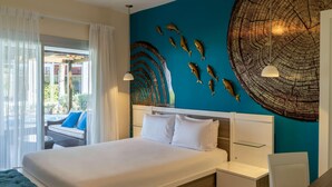 A modern hotel room with a large bed, a wall-mounted fish decoration, and a view of the outdoors. - Blue Beach Punta Cana Luxury Resorts (Punta Cana)