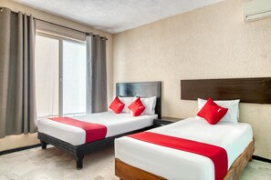 A hotel room with two beds, a large window, and an air conditioning unit. - Capital O Hotel La Siesta, Gomez Palacio (Gomez Palacio)