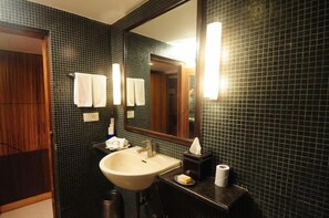 A bathroom with a sink, mirror, towel rack, and a tissue box. - Justa The Residence Hyderabad (Hyderabad)