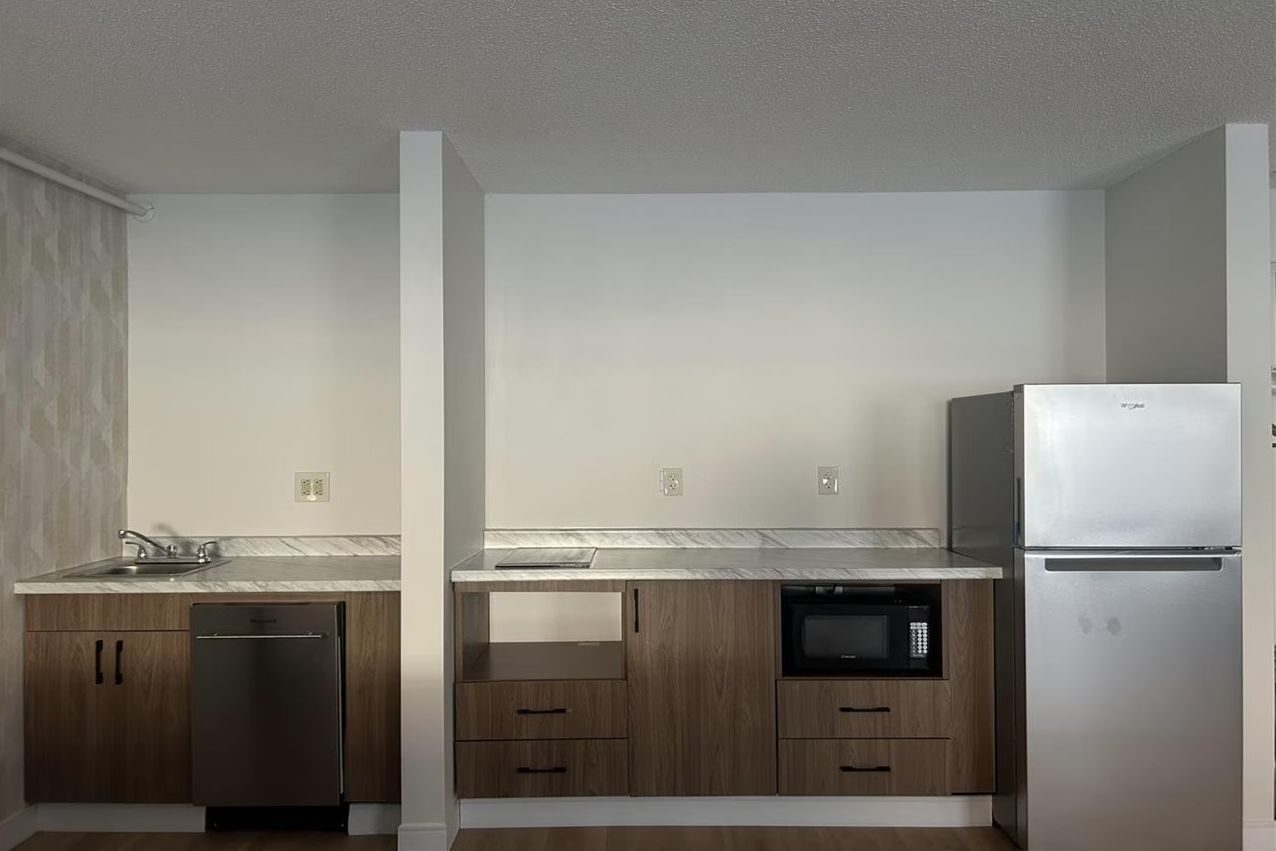A modern kitchen with a dishwasher, microwave, and refrigerator.