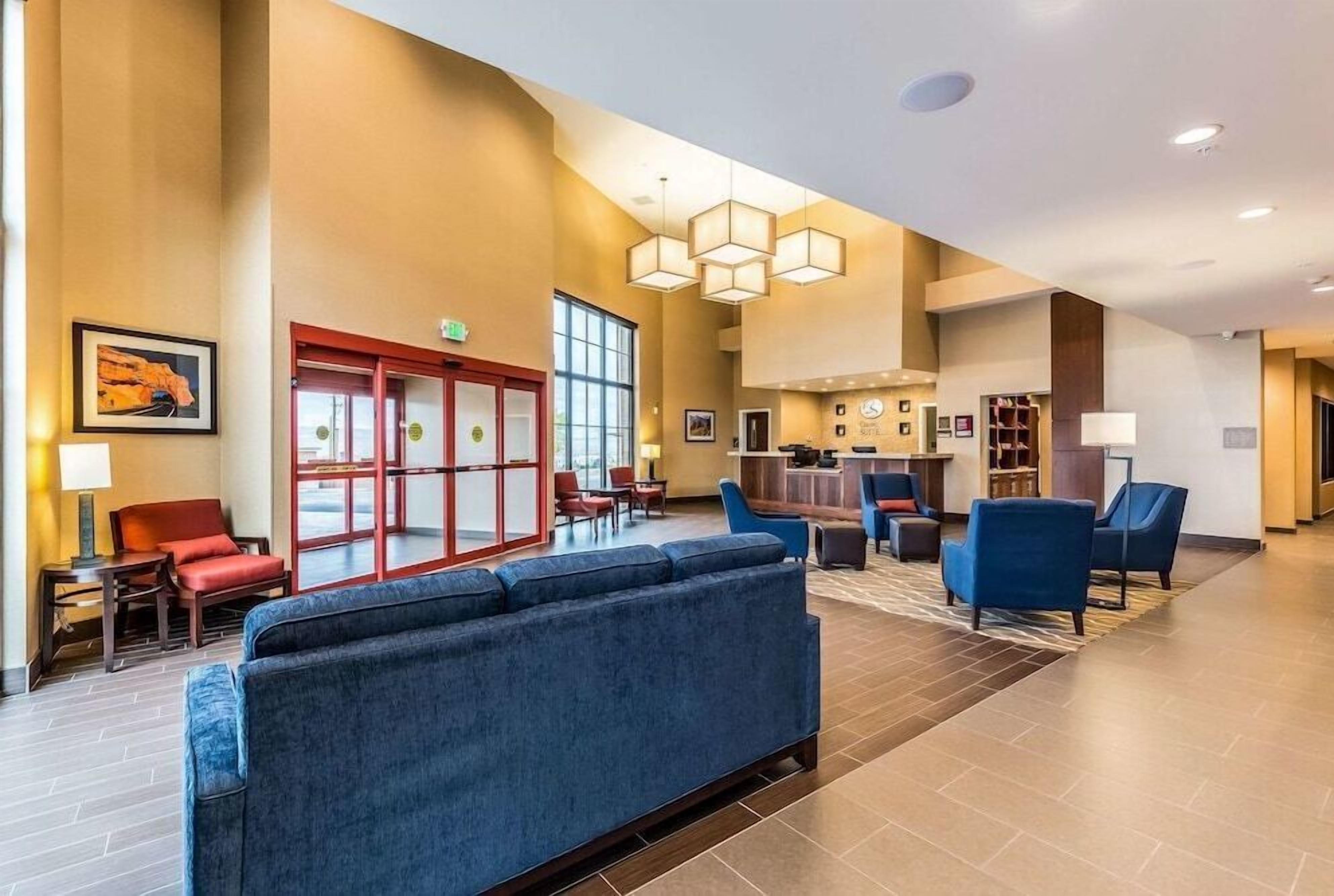 A hotel lobby with a reception desk, seating area, and a large window.