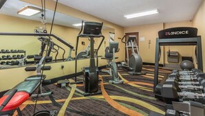 A gym with exercise equipment, a bench, and a mirror. - Warsaw I-40 (Warsaw)