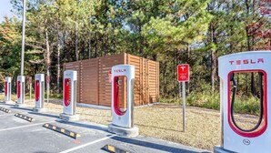A Tesla charging station with a wooden structure in the background. - Warsaw I-40 (Warsaw)