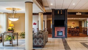 Un vestíbulo de hotel con chimenea, zona de estar y comedor.