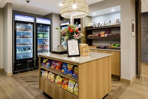 A snack bar with a display of chips and a beverage cooler. - Graystone Lodge, an Ascend Collection Hotel (Boone)