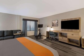 A hotel room with a bed, a desk, a chair, a TV, and a window with curtains. - Graystone Lodge, an Ascend Collection Hotel (Boone)