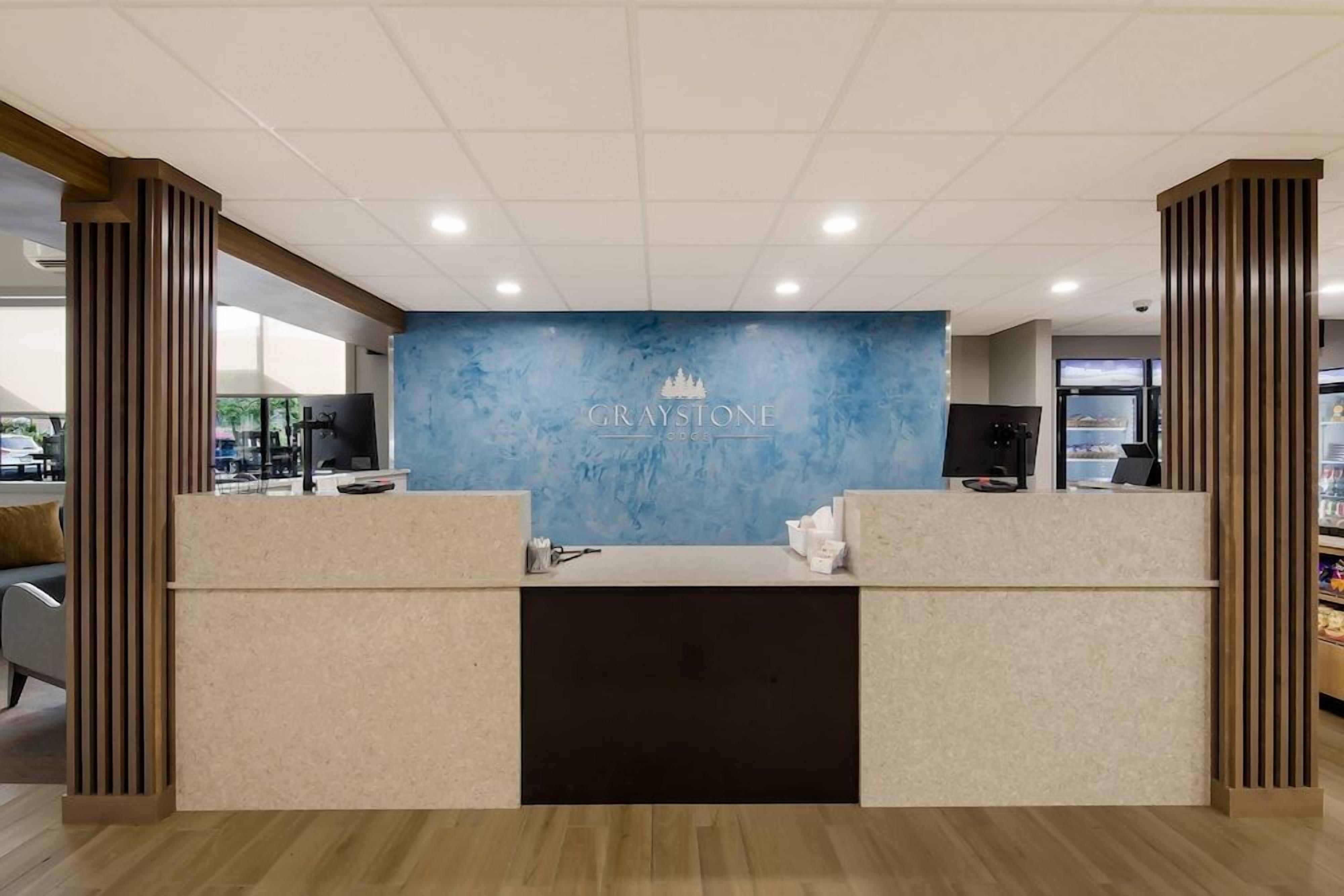 A reception area with a blue wall, a logo, and a counter.