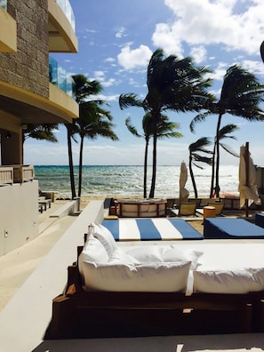 A beachside hotel with a pool area, lounge chairs, and palm trees. - Thompson Playa Del Carmen Beach House (Playa del Carmen)