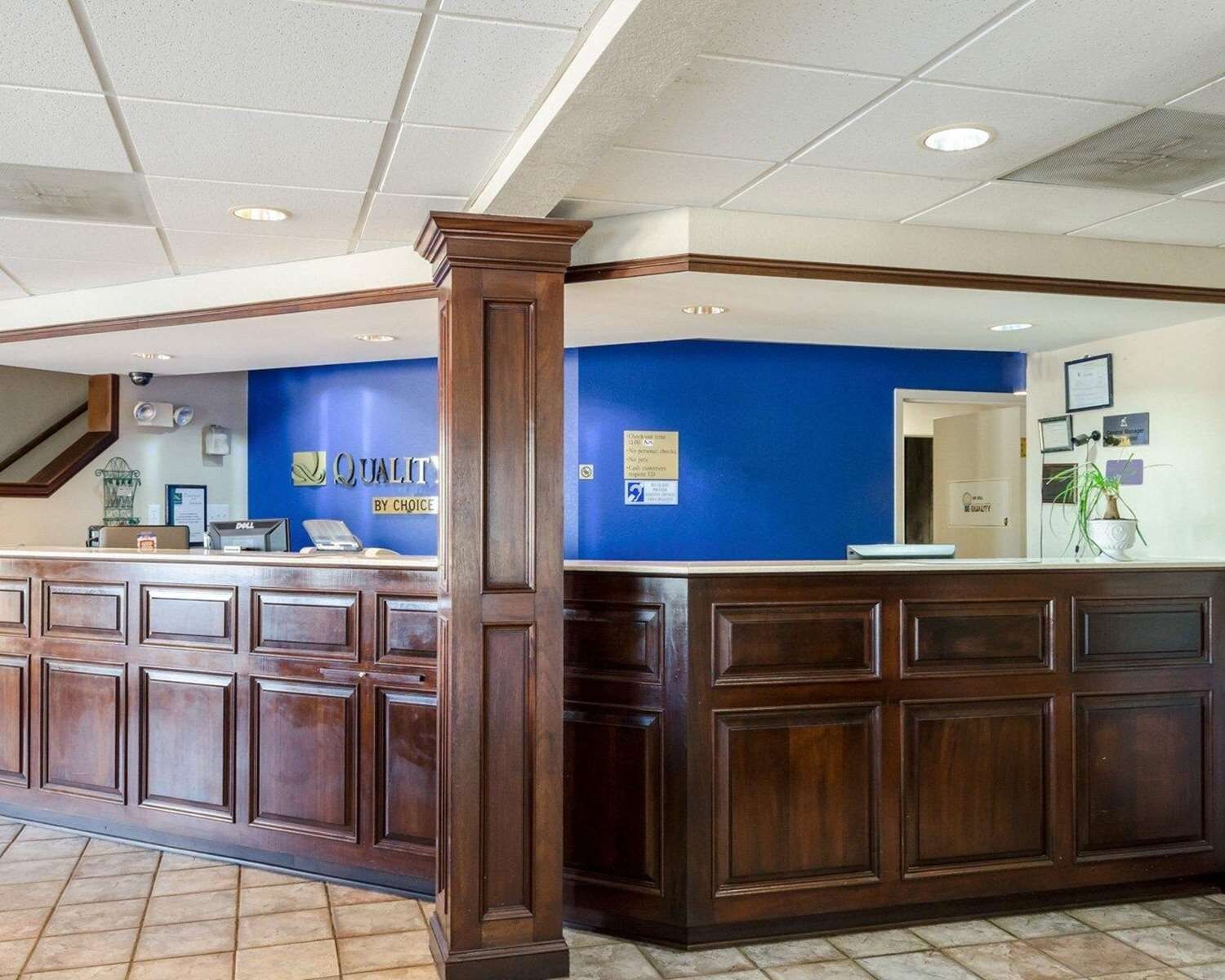A reception desk with a blue wall and a wooden counter.