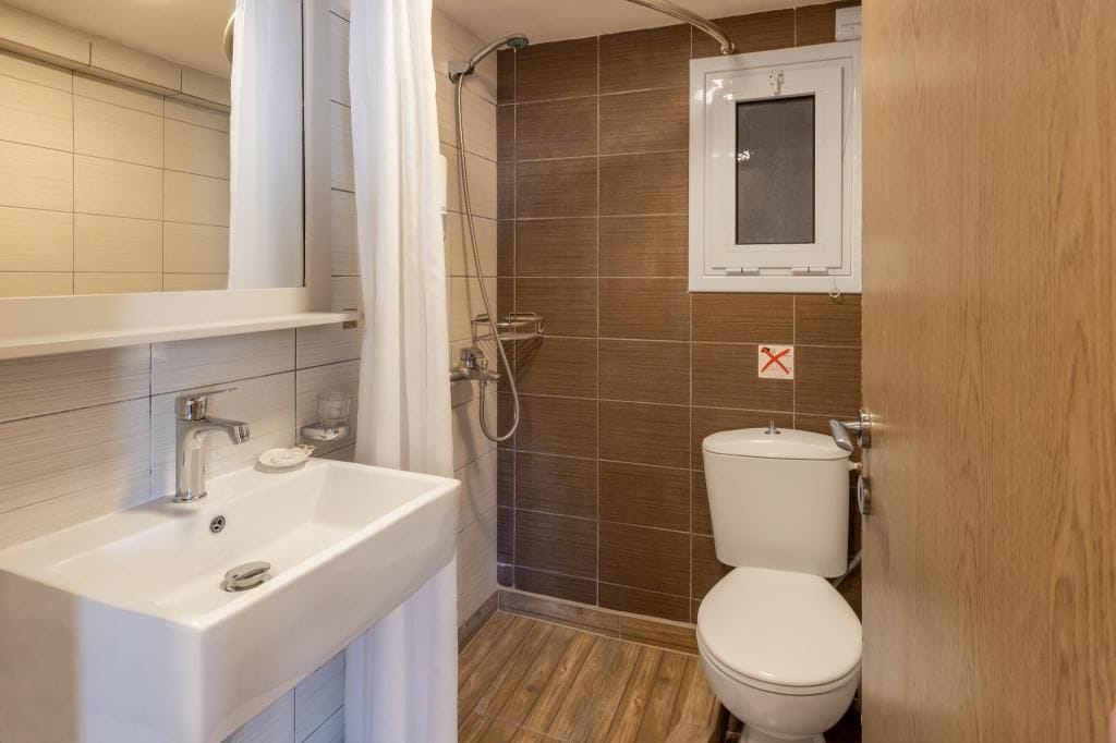 A bathroom with a white sink, a shower, and a toilet.