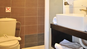 Un baño con inodoro, ducha y lavamanos.
