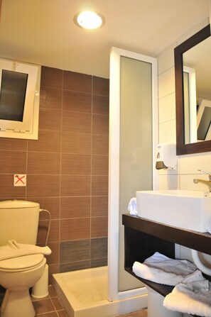 A bathroom with a toilet, a shower, and a sink. - Kos City Sunstone Hotel (Kos)