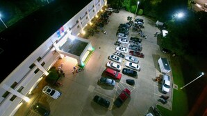 Una estructura de estacionamiento de varios pisos contigua a un edificio con un letrero que dice 'Studio 6'.