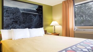 A hotel room with a bed, a nightstand with a lamp, a telephone, and a window with curtains. - Super 8 Beckley (Beckley)