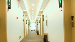A hotel corridor with a central walkway, directional signs, and a patterned floor. - Greentree Inn Linxia Autonomous Prefecture Linxia Oxford River Avenue Express Hotel (Linxia)